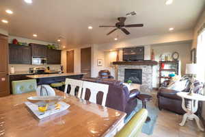 Dining space with ceiling fan, a fireplace, and sink