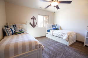 Carpeted bedroom featuring ceiling fan