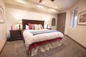 Bedroom featuring ceiling fan and dark carpet