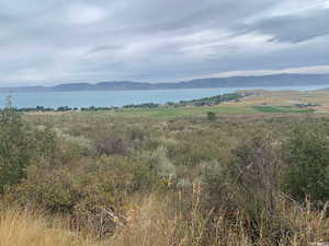 Property view of mountains featuring a water view and a rural view