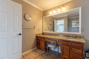 Bathroom featuring vanity, ornamental molding, and tile patterned floors