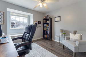 Home office with dark hardwood / wood-style floors and ceiling fan