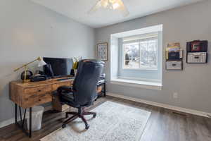 Home office featuring dark hardwood / wood-style flooring and ceiling fan