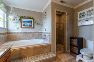 Full bathroom featuring crown molding, tile patterned floors, toilet, and plus walk in shower