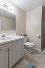 Bathroom with vanity, tile patterned flooring, a textured ceiling, and toilet