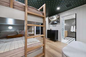 Bedroom with hardwood / wood-style flooring and ensuite bathroom