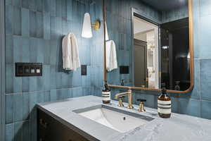 Bathroom with tile walls and vanity