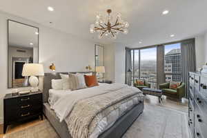 Bedroom featuring light hardwood / wood-style floors, a chandelier, and expansive windows