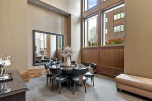 Dining room featuring carpet flooring and a high ceiling