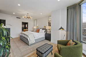 Bedroom featuring light wood-type flooring and a notable chandelier