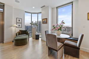 Dining space with a wall of windows, light hardwood / wood-style floors, and a healthy amount of sunlight