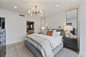 Bedroom featuring light hardwood / wood-style floors and an inviting chandelier