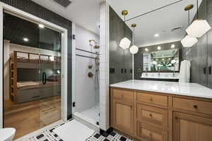 Bathroom with vanity, wood-type flooring, and a tile shower