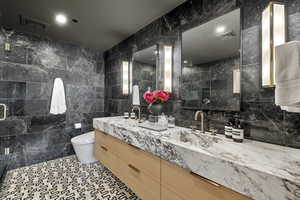 Bathroom with vanity, tile walls, toilet, and tile patterned flooring