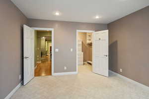 Carpeted bedroom featuring a spacious closet and a closet