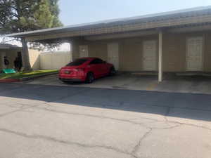 View of parking / parking lot featuring a carport