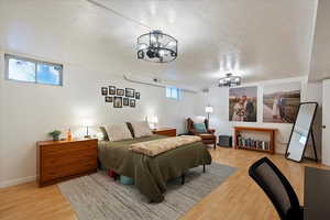 Appt. Bedroom with a notable chandelier, wood-type flooring, and a textured ceiling