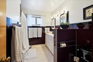 Bathroom featuring vanity and tile walls