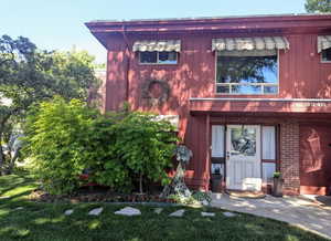 Entrance to property with a garage and a lawn