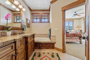 Bathroom featuring ornamental molding, vanity, ceiling fan, tile patterned flooring, and a washtub