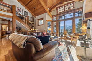 Living room with high vaulted ceiling, a mountain view, wooden ceiling, an inviting chandelier, and light hardwood / wood-style flooring