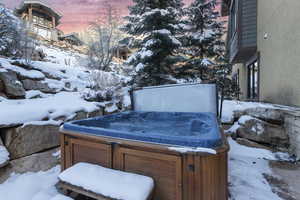 Yard layered in snow featuring a hot tub