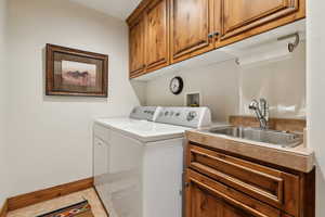 Washroom featuring cabinets, separate washer and dryer, and sink