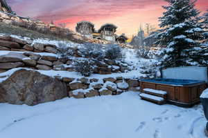 Yard covered in snow featuring a hot tub