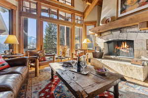 Living room with tile patterned flooring, a fireplace, and a high ceiling