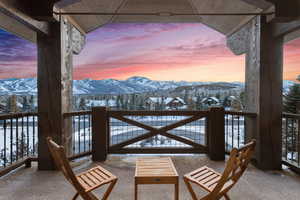 Snow covered back of property with a mountain view