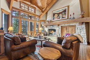 Living room with high vaulted ceiling, a fireplace, beamed ceiling, hardwood / wood-style flooring, and wood ceiling