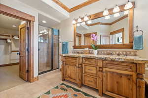 Bathroom with crown molding, vanity, a wealth of natural light, tile patterned floors, and walk in shower