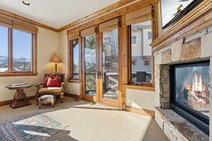 Sitting room featuring ornamental molding, a mountain view, plenty of natural light, and a stone fireplace