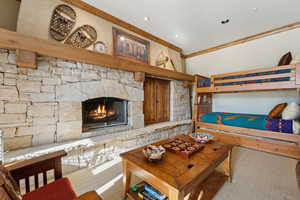 Bedroom with light colored carpet and a fireplace