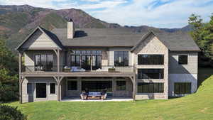 Back of property with a balcony, outdoor lounge area, a yard, a mountain view, and a patio area