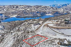 Snowy aerial view featuring a water and mountain view