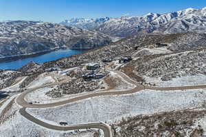 Snowy aerial view featuring a water and mountain view