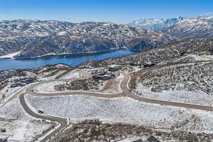 Snowy aerial view featuring a water and mountain view