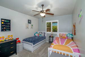 Carpeted bedroom featuring ceiling fan