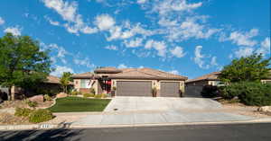 View of front of house with a garage and a front lawn