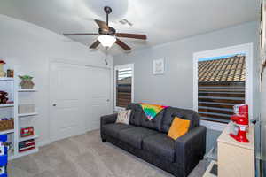 Carpeted living room with ceiling fan