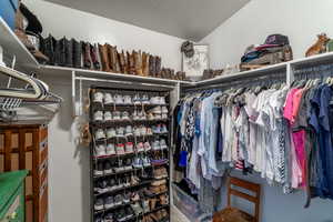 Walk in closet with lofted ceiling and carpet flooring