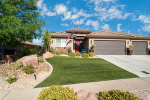 View of front of house with a garage and a front lawn