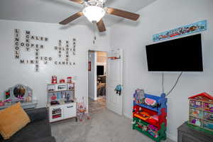 Game room with ceiling fan and carpet