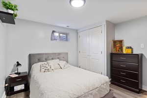 Bedroom with light hardwood / wood-style floors and a closet