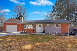 Single story home with a garage and a front lawn