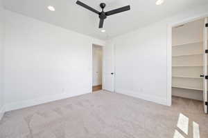 Unfurnished bedroom with carpet floors, recessed lighting, baseboards, and a walk in closet