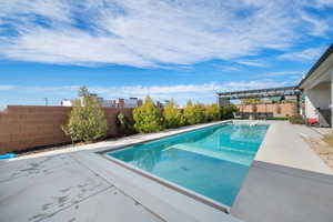 View of pool with a pergola and a patio