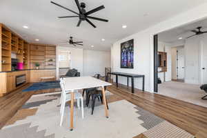 Dining space with ceiling fan and light wood-type flooring