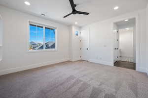 Unfurnished bedroom featuring ceiling fan and carpet floors